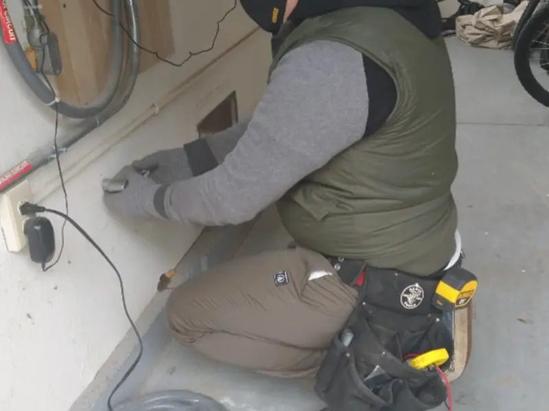 Electrician performing outlet wiring in a Laguna Woods garage
